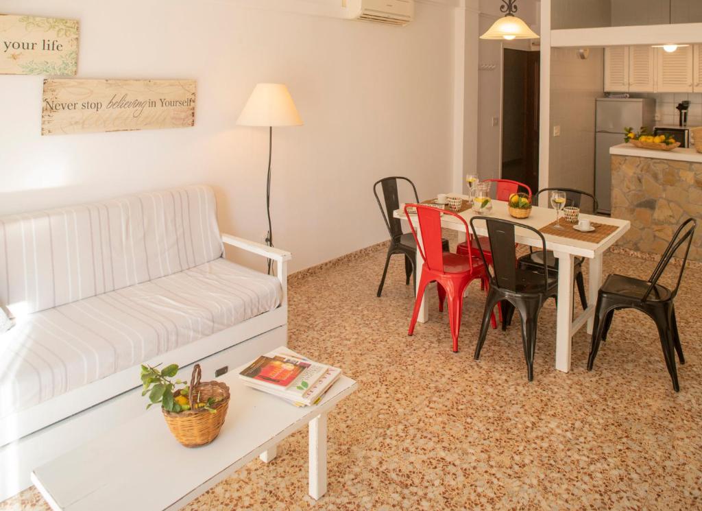 sala de estar con sofá, mesa y sillas en Sa Barda - Formentera Break, en Sant Ferran de Ses Roques