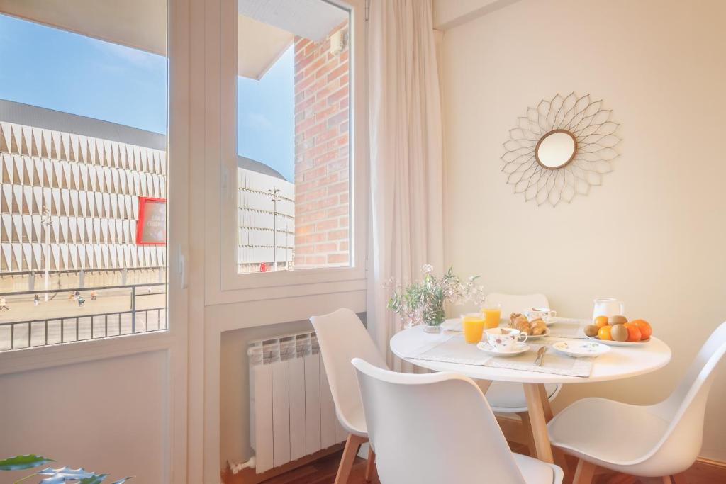jadalnia ze stołem i krzesłami oraz oknem w obiekcie San Mames Apartment - Free Parking w mieście Bilbao
