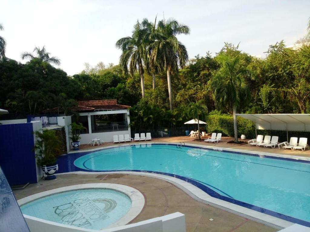 a large swimming pool in a resort with palm trees at Condominio Girardot Resort in Girardot
