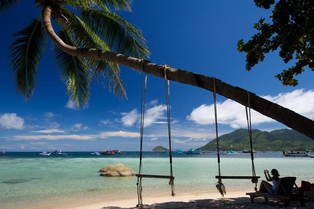 eine Person, die auf einer Schaukel am Strand sitzt in der Unterkunft Koh Tao Royal Resort in Ko Tao