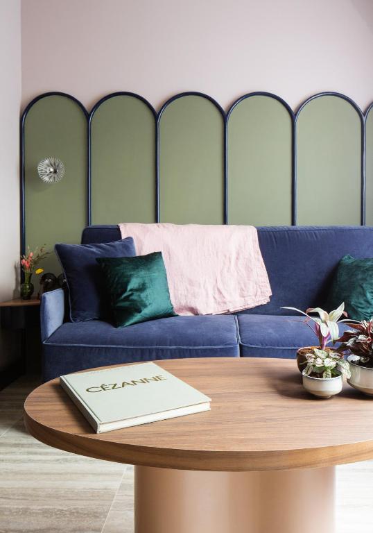 un salon avec un canapé bleu et une table dans l'établissement Joie Paris GARE MONTPARNASSE, à Paris