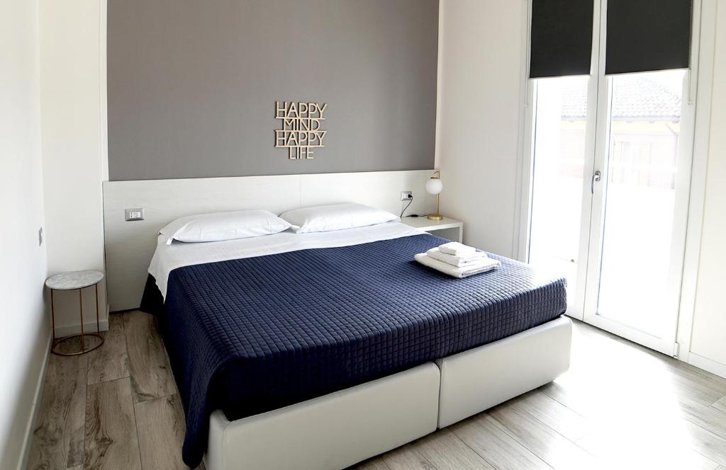 ein Schlafzimmer mit einem Bett mit blauer Bettdecke in der Unterkunft Bianca Room & Breakfast in Bologna