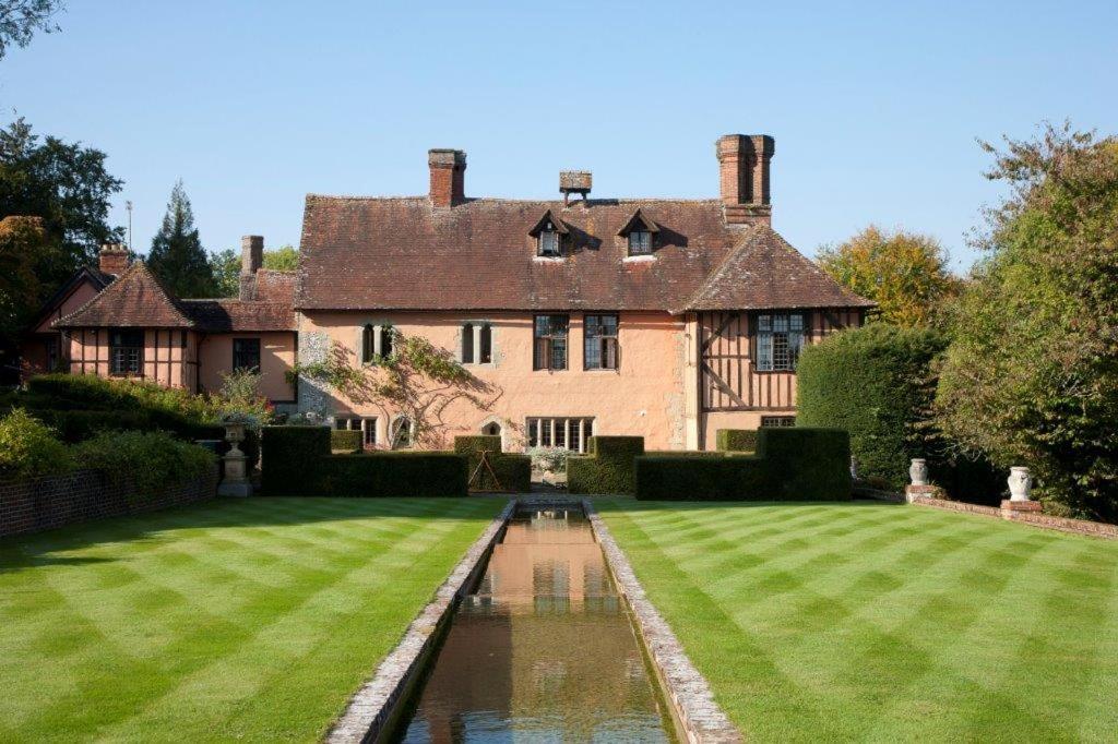 una casa grande con un estanque en el patio en King Johns House, en Salisbury