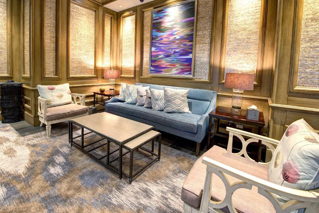 ein Wohnzimmer mit einem blauen Sofa und Stühlen in der Unterkunft Beau Rivage Resort &amp; Casino in Biloxi