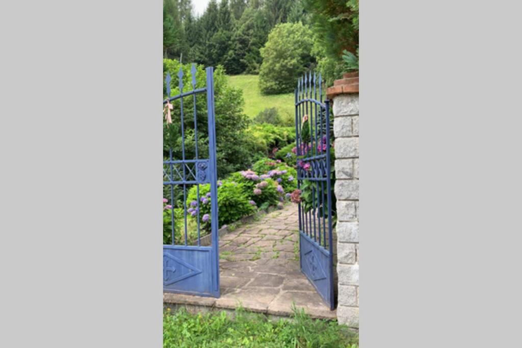 una entrada a un jardín con puertas azules en Paola’s Country Home - Vanoi Primiero Trentino en Canale San Bovo