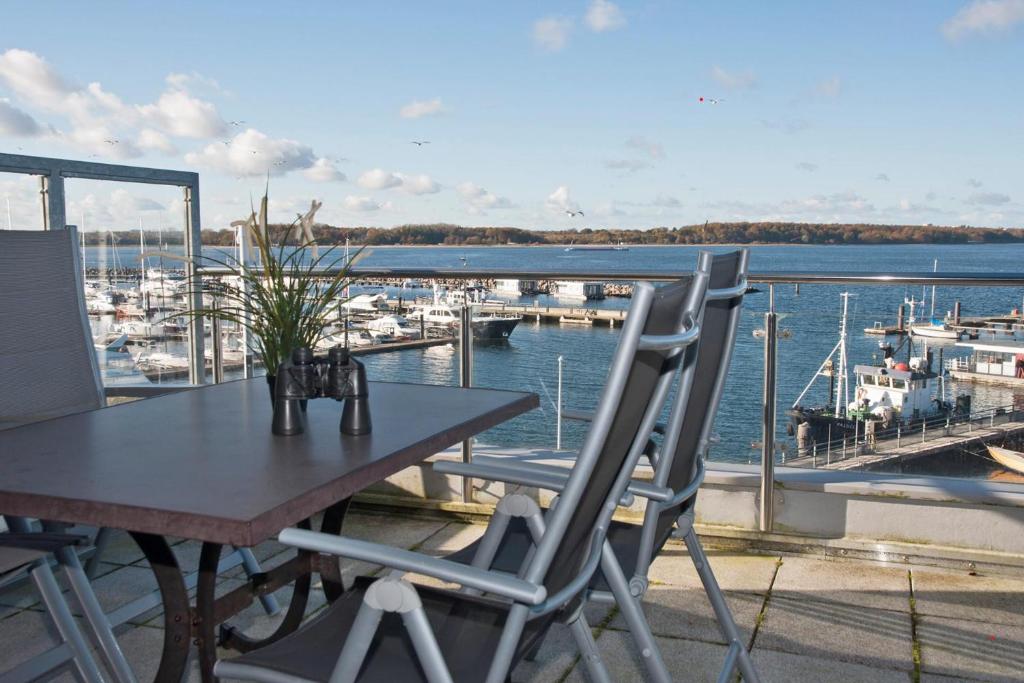 a table and chairs on a balcony with a marina at BRN Fliegender Hollaender in Laboe