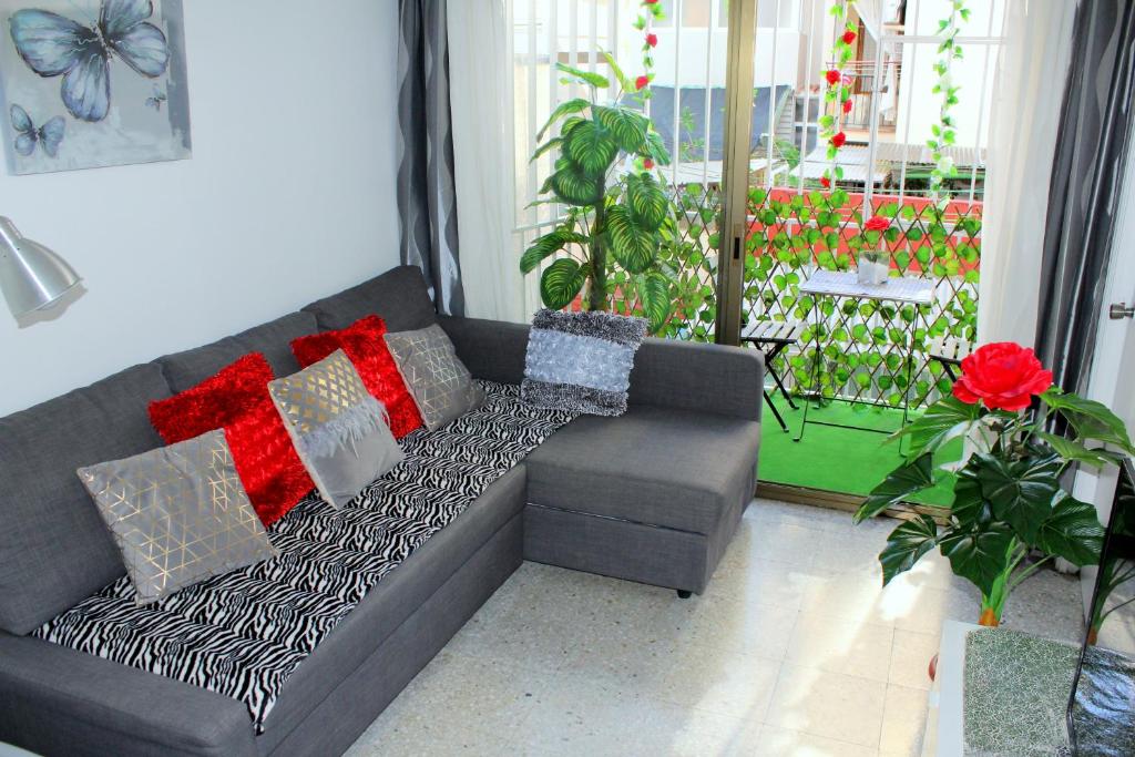 ein Sofa mit Kissen darauf im Wohnzimmer in der Unterkunft Cosmo Grey in Hospitalet de Llobregat