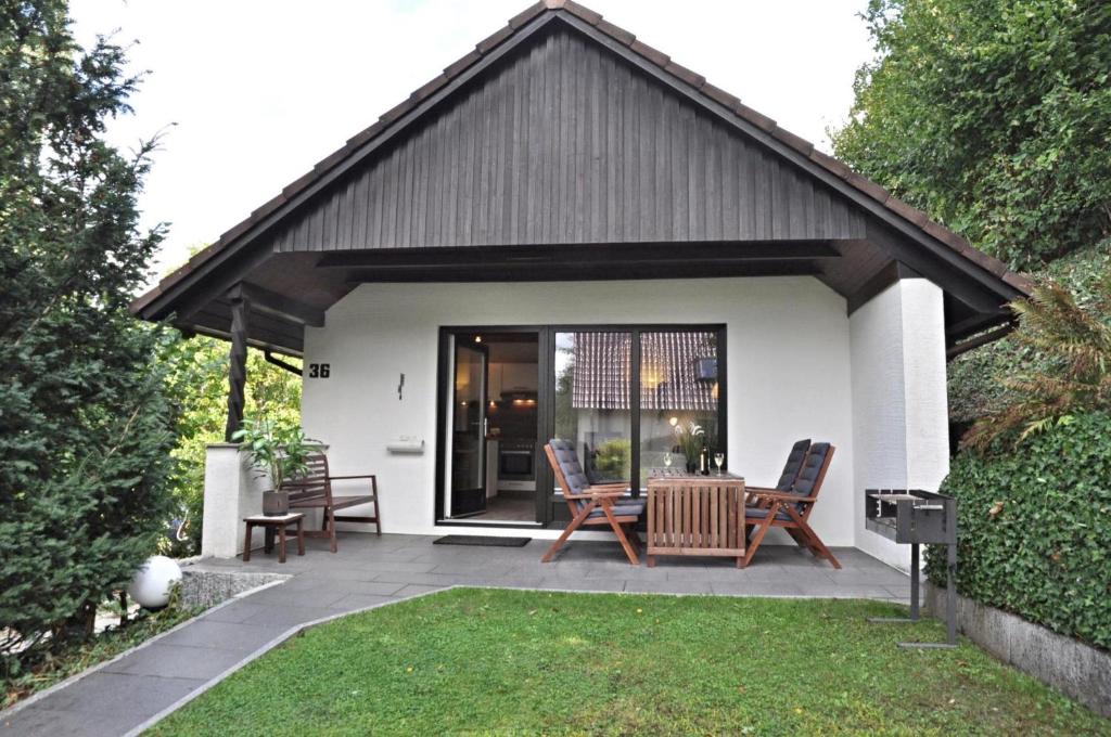 a patio with a table and chairs in a backyard at PW Strandmuschel in Laboe