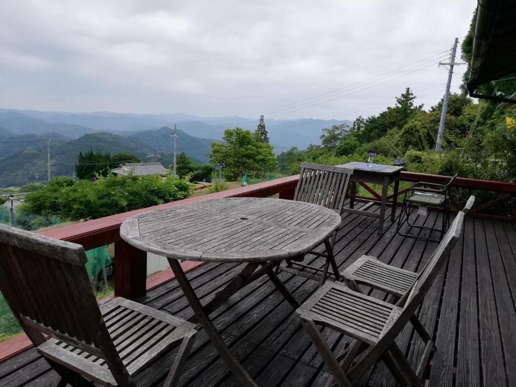 a wooden table and chairs on a deck with a view at みなみ野フィールズ不動坂 in Nachikatsuura