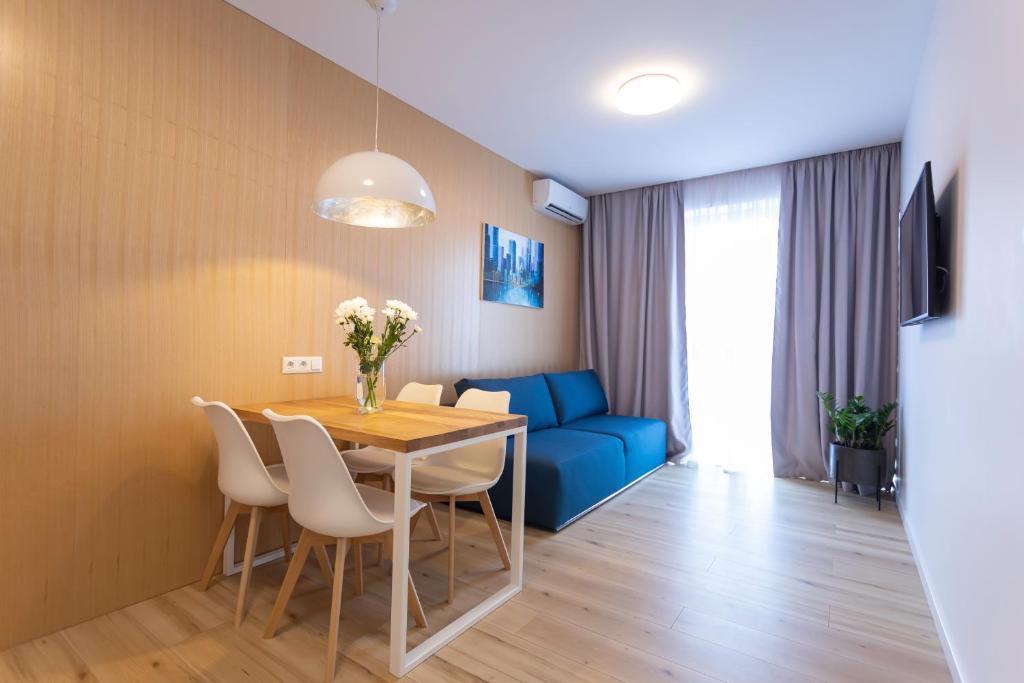 una sala da pranzo con tavolo e divano blu di 23441 Cozy apartment nearby with Central Railway Station a Kiev