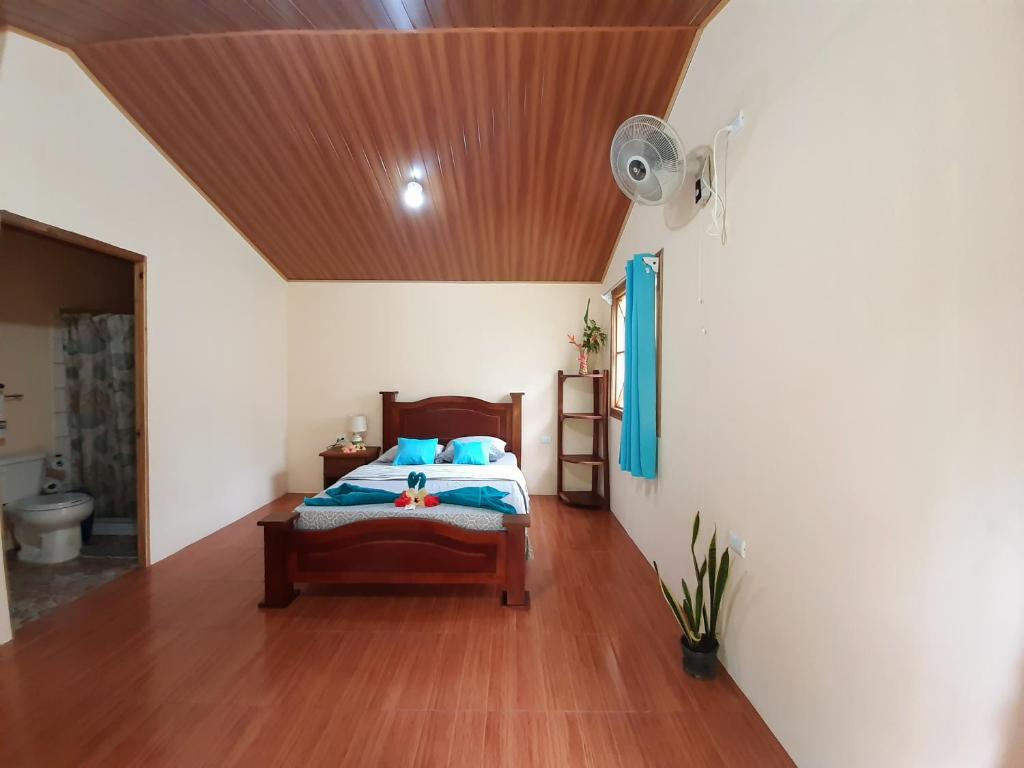 1 dormitorio con cama y techo de madera en Garden of Heliconias Lodge en Drake