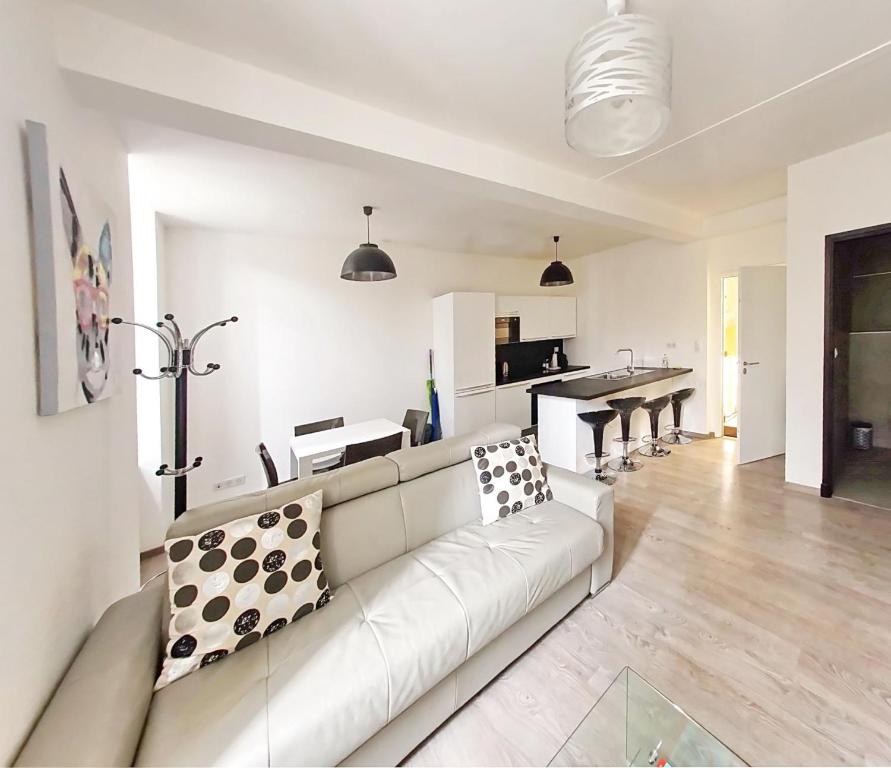 a living room with a white couch and a kitchen at Brand new 2 BR Gambetta Fully Renovated 2021- 5 mns Palais by Olam Properties in Cannes