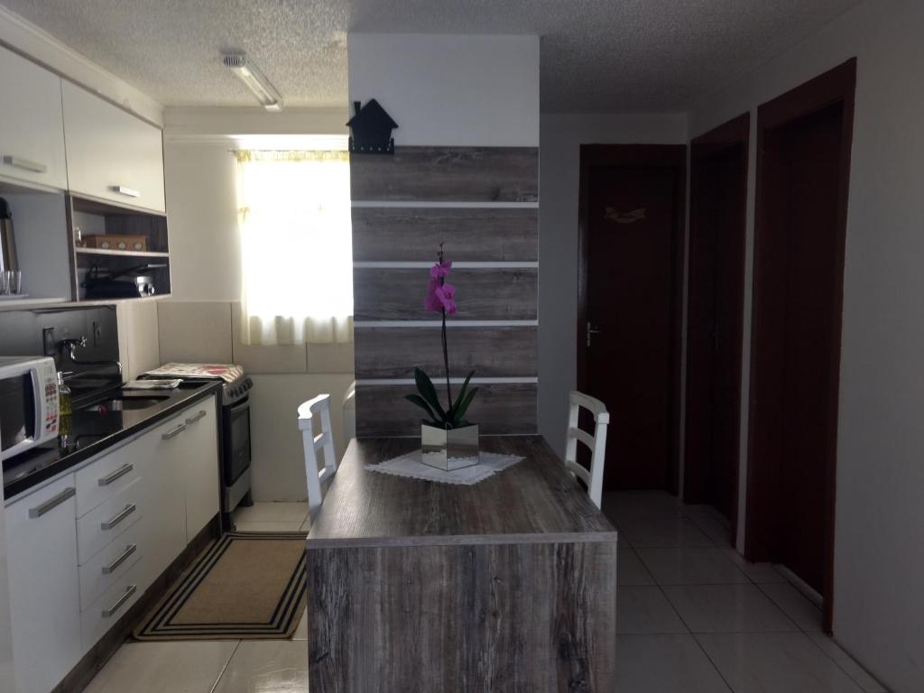 a kitchen with a wooden island in the middle at Aptos Farroupilha in Farroupilha
