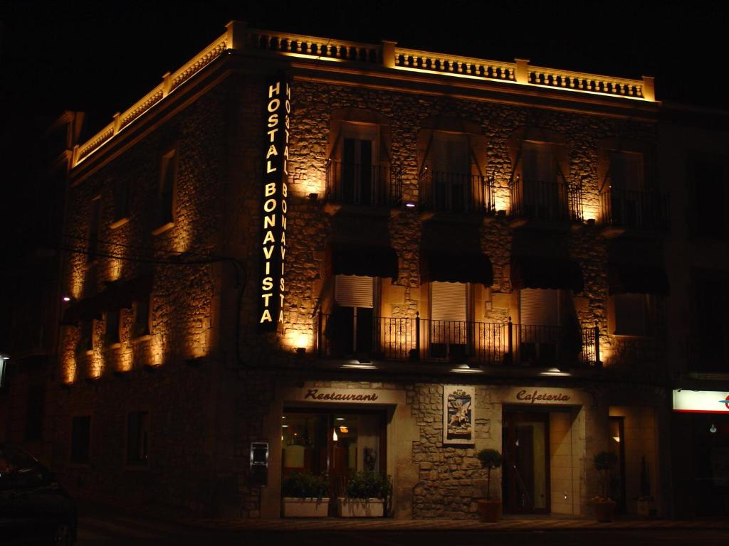 a building with a sign on the side of it at night at Hostal Bonavista in Cervera