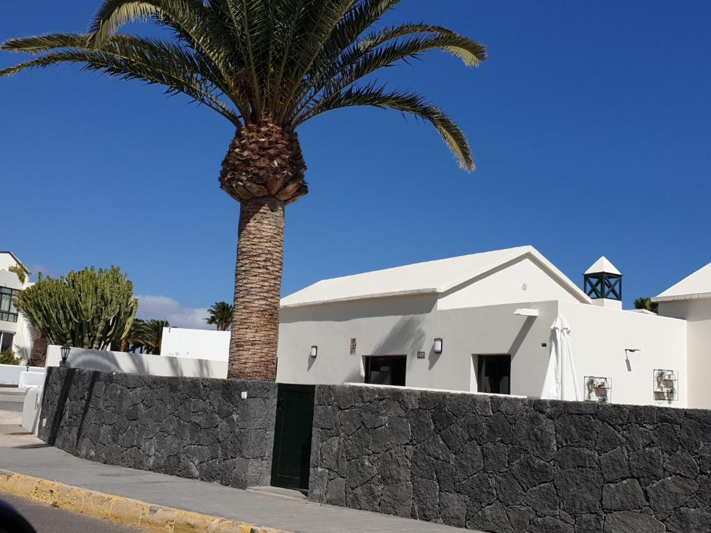 コスタ・テギセにあるCasa a primera linea de marの白い建物前のヤシの木