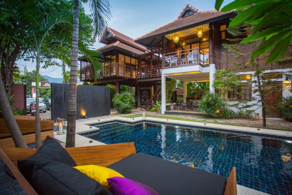 a house with a swimming pool in front of a house at Tolani Northgate Villa Chiang Mai in Chiang Mai