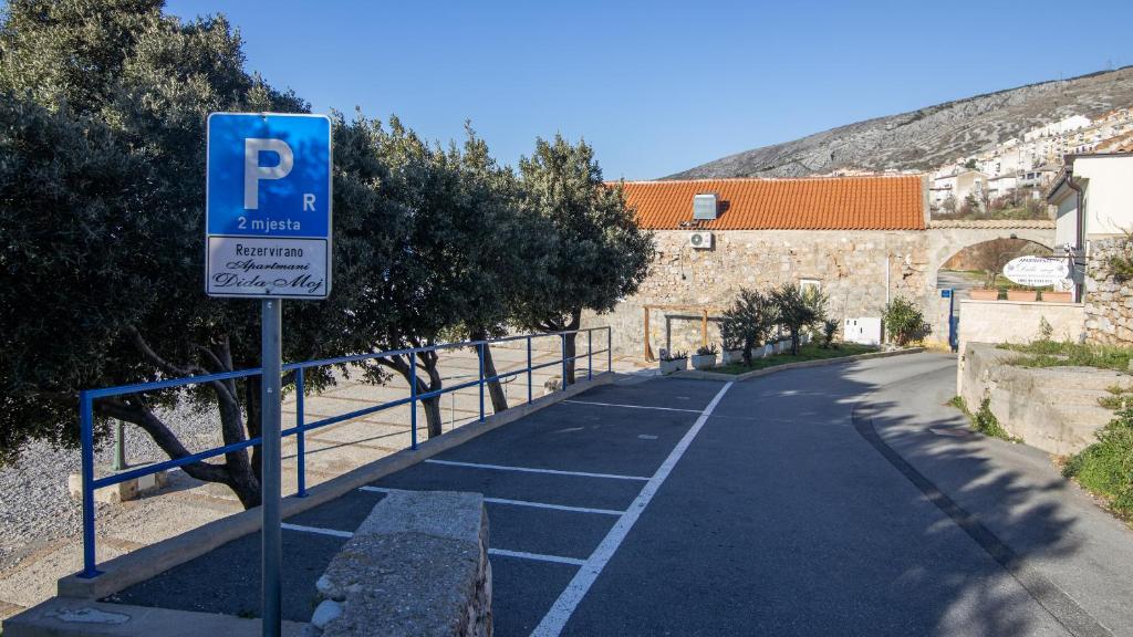 a parking lot with a blue parking sign next to a building at Dida moj in Senj