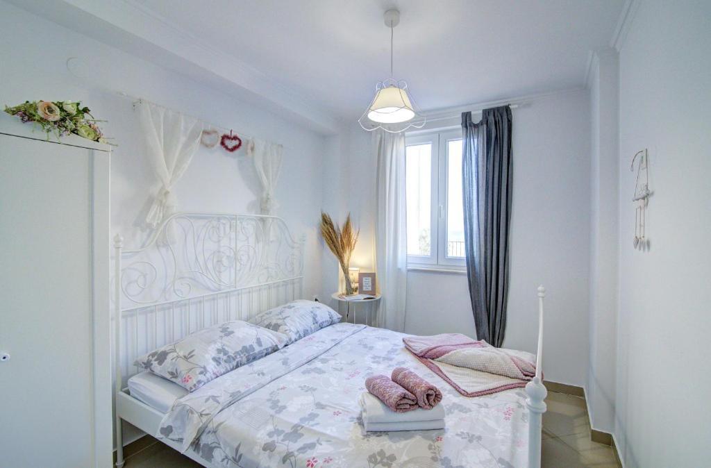 a bedroom with a white bed with pink shoes on it at Dida moj in Senj