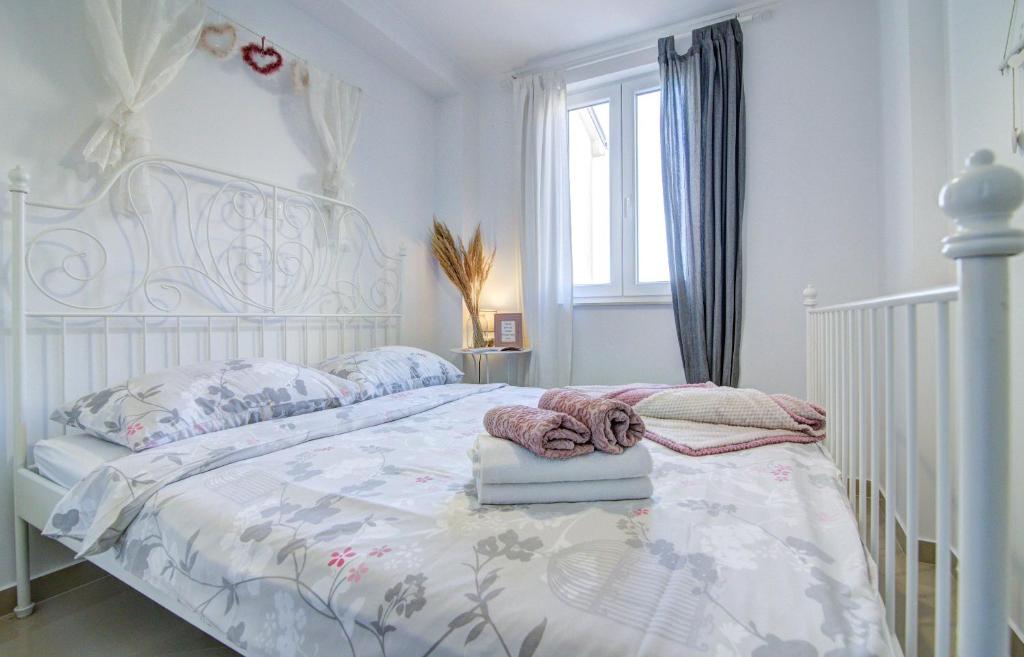 a bedroom with a white bed with a white crib at Dida moj in Senj