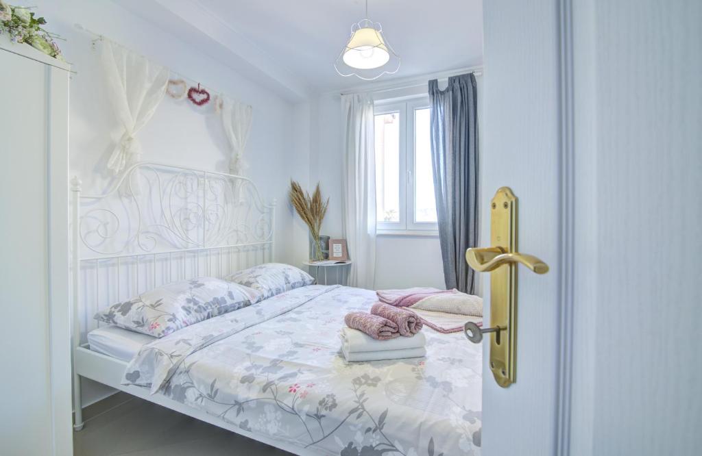a bedroom with a bed with a white bedspread and a window at Dida moj in Senj
