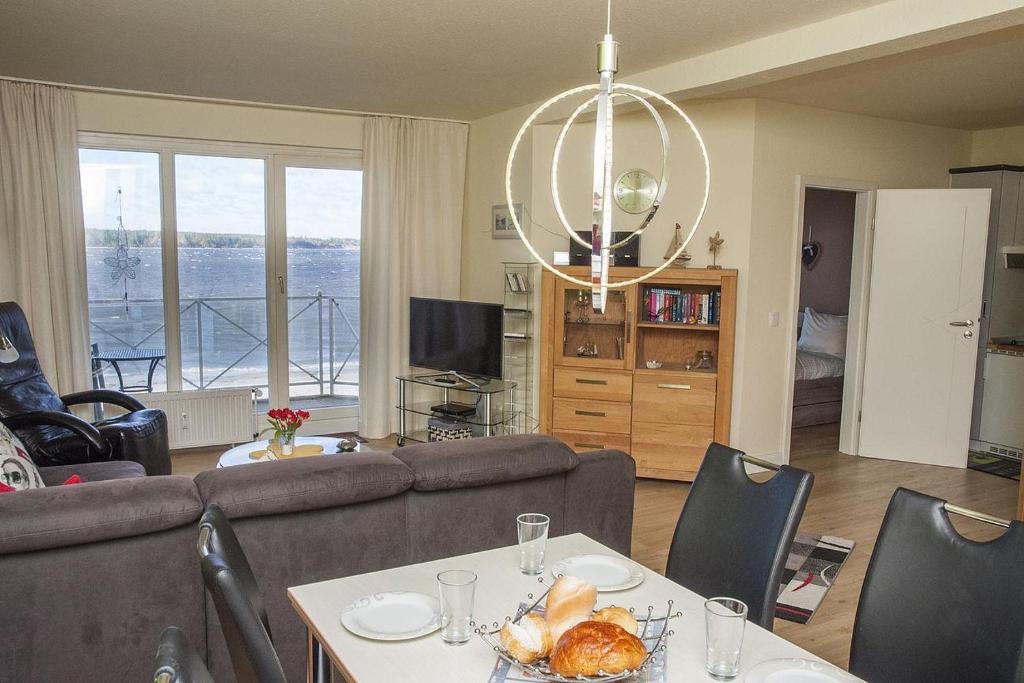 ein Wohnzimmer mit Sofa und Tisch mit Essen drauf in der Unterkunft Strandhotel 26 in Laboe