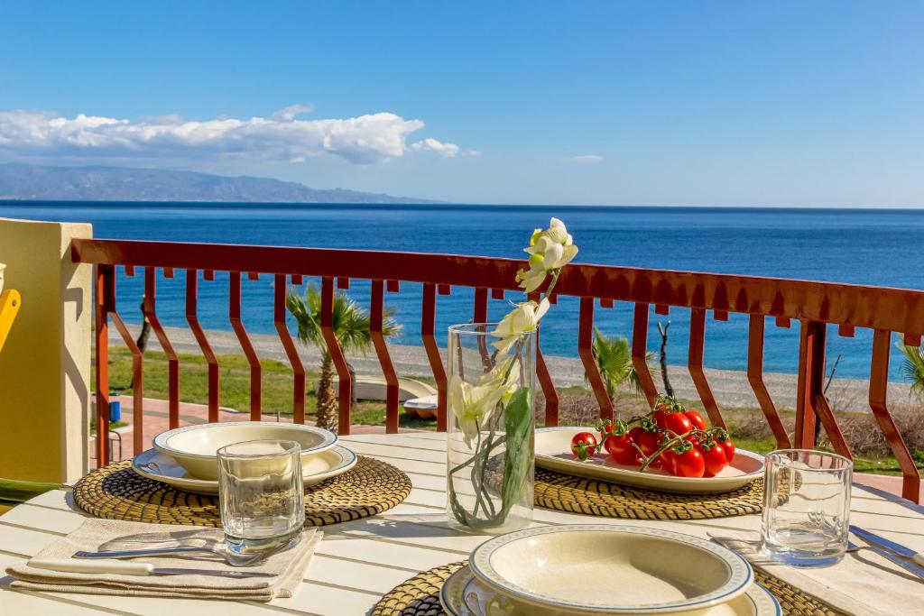 una mesa con platos de comida y vistas al océano en La Plage - Home and Sea en Nizza di Sicilia