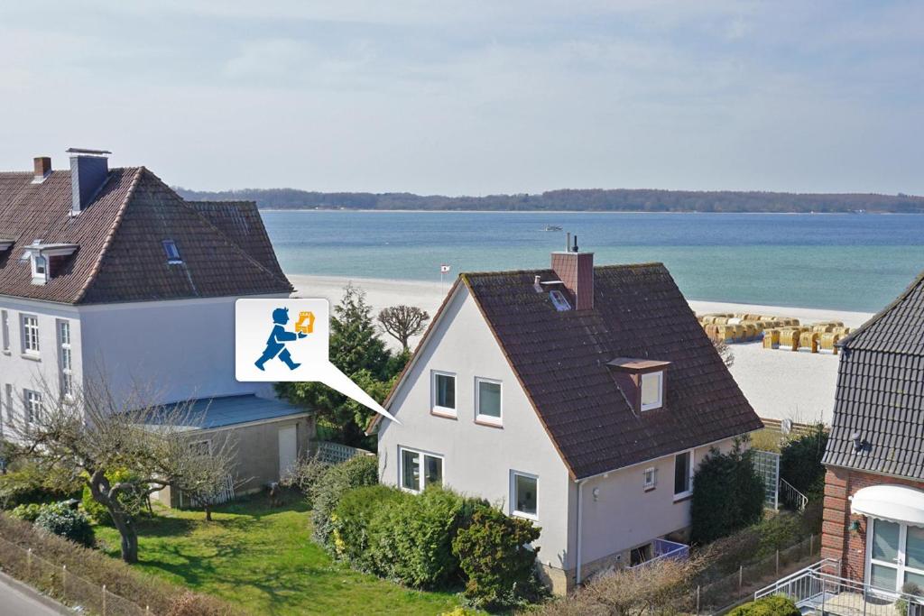 a house with a sign with a person walking on it at Strandhaus 19b in Laboe