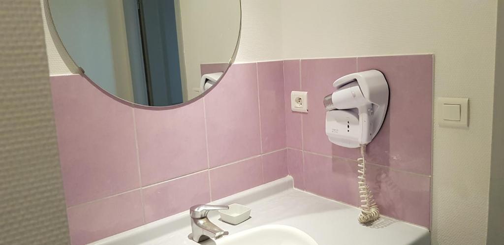 a bathroom with a sink and a mirror at Hôtel Terminus in Luz-Saint-Sauveur