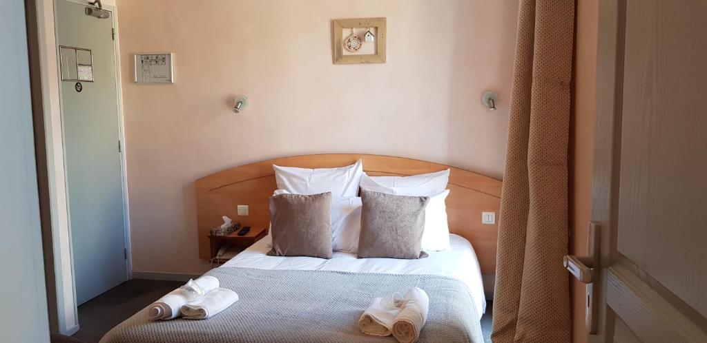 a bedroom with a bed with two towels on it at Hôtel Terminus in Luz-Saint-Sauveur