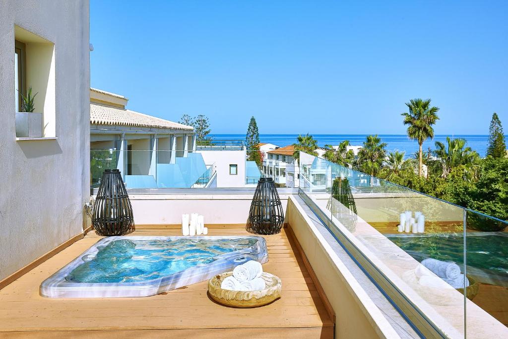 een balkon met een hot tub en een zwembad bij Castello Boutique Resort & Spa - Adults Only in Sissi