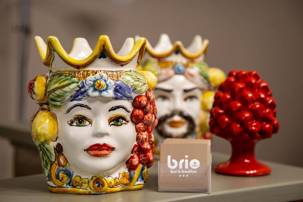 two statues of masks with crowns on a table at Brio Bed & Breakfast in Agrigento