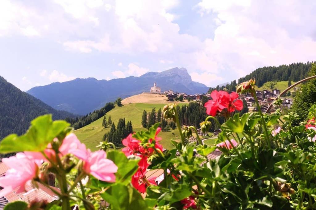 a field of flowers with a castle on a hill at La Majon in Colle Santa Lucia