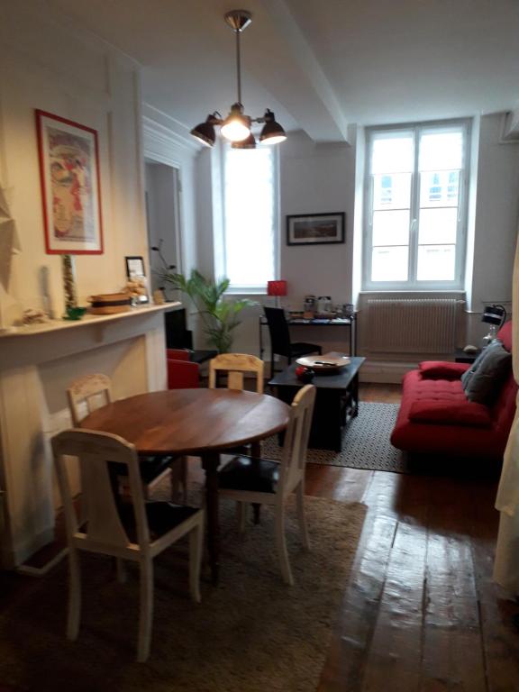 un salon avec une table et un canapé dans l'établissement Appartement la haute ville Granville, à Granville