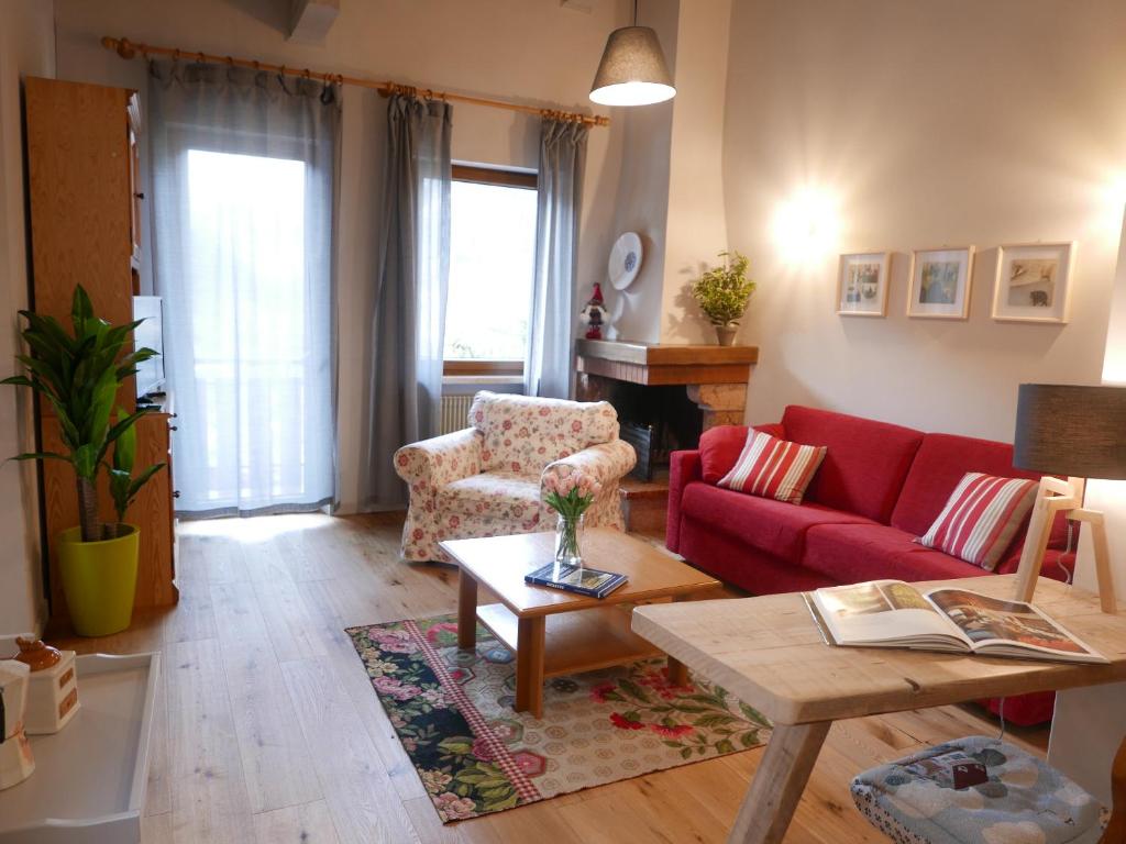 un soggiorno con divano rosso e tavolo di Monte Pelmo ad Alleghe