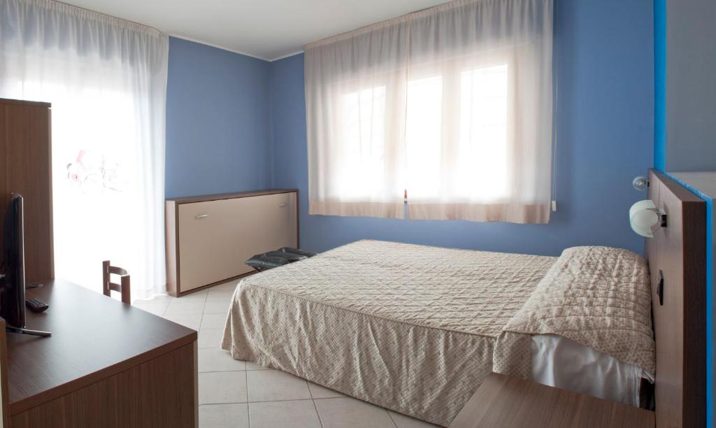 a blue bedroom with a bed and a window at La Lanterna in Silvi Marina