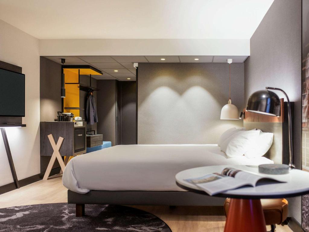 a bedroom with a large bed and a table at Mercure Amsterdam City Hotel in Amsterdam