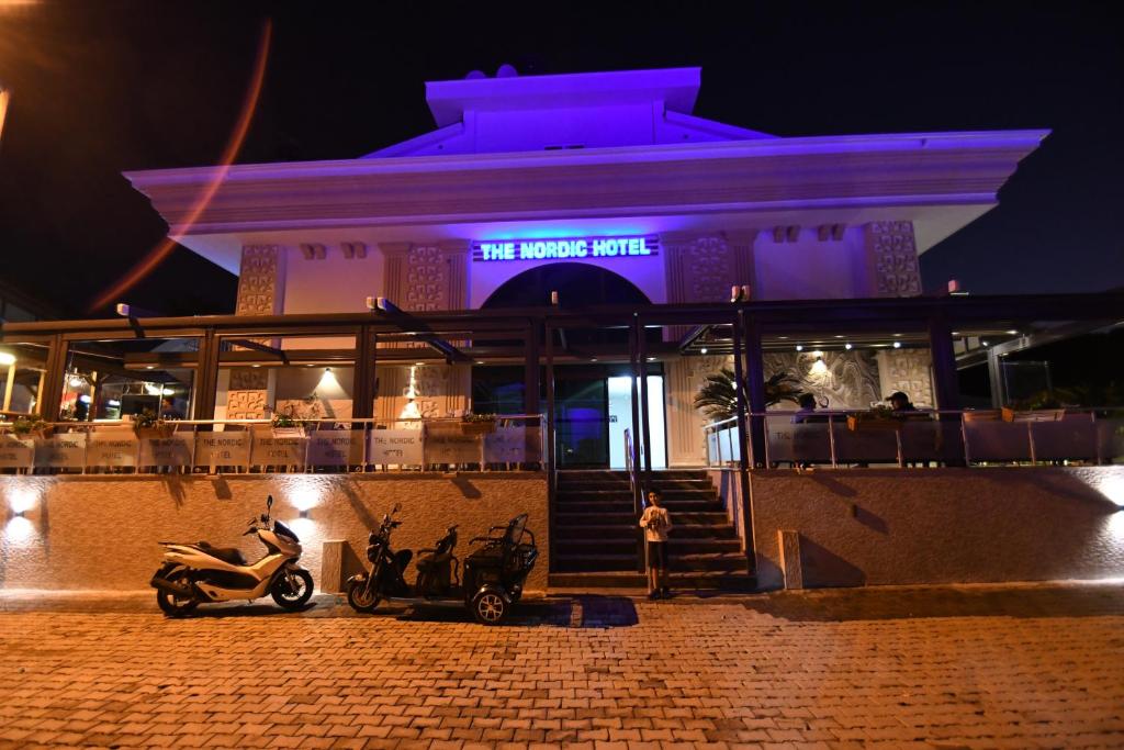 a building with two scooters parked outside at night at THE NORDİC HOTEL in Kemer