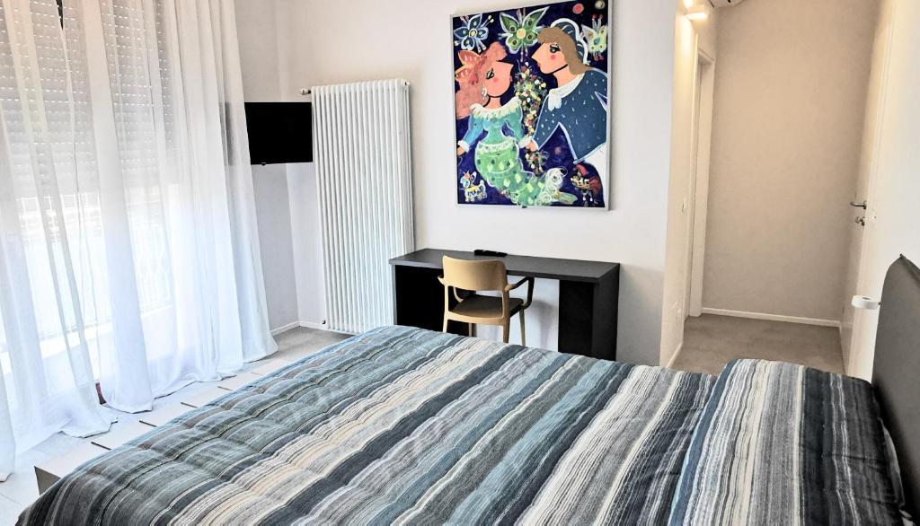 Dormitorio con cama, escritorio y pintura en Casa Dora, en Cesena