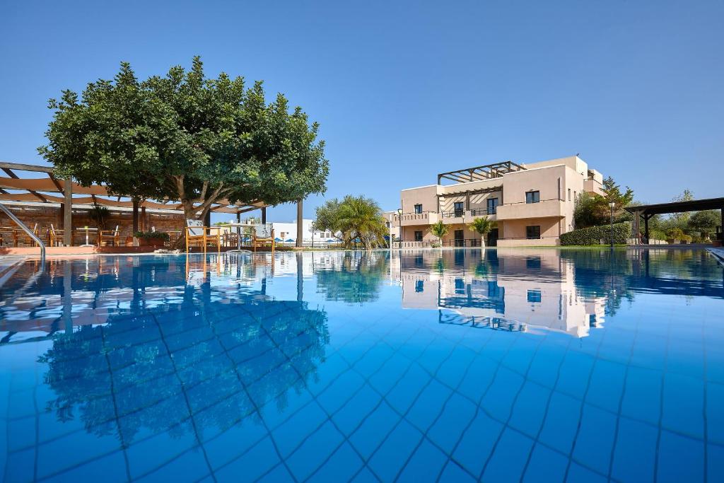 una piscina vacía con un árbol y un edificio en Vasia Resort & Spa, en Sissi