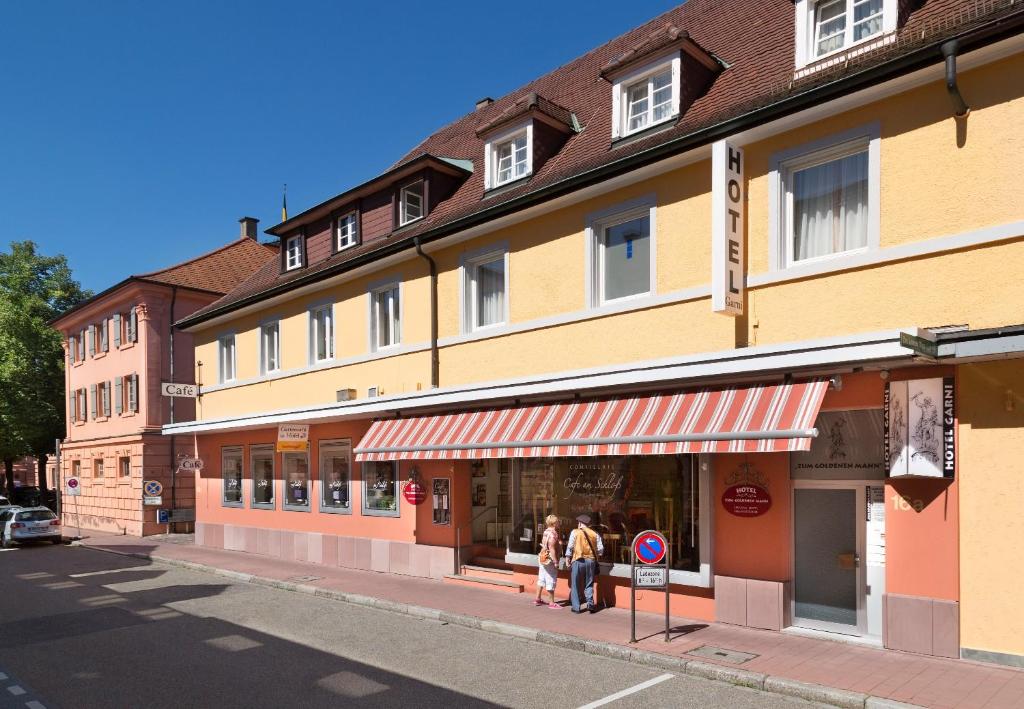 un grupo de personas de pie en frente de un edificio en Hotel Zum Goldenen Mann, en Rastatt