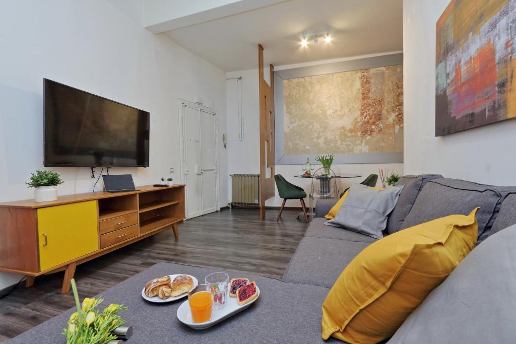 un soggiorno con divano e TV a schermo piatto di Urbana Delicious Flat a Roma