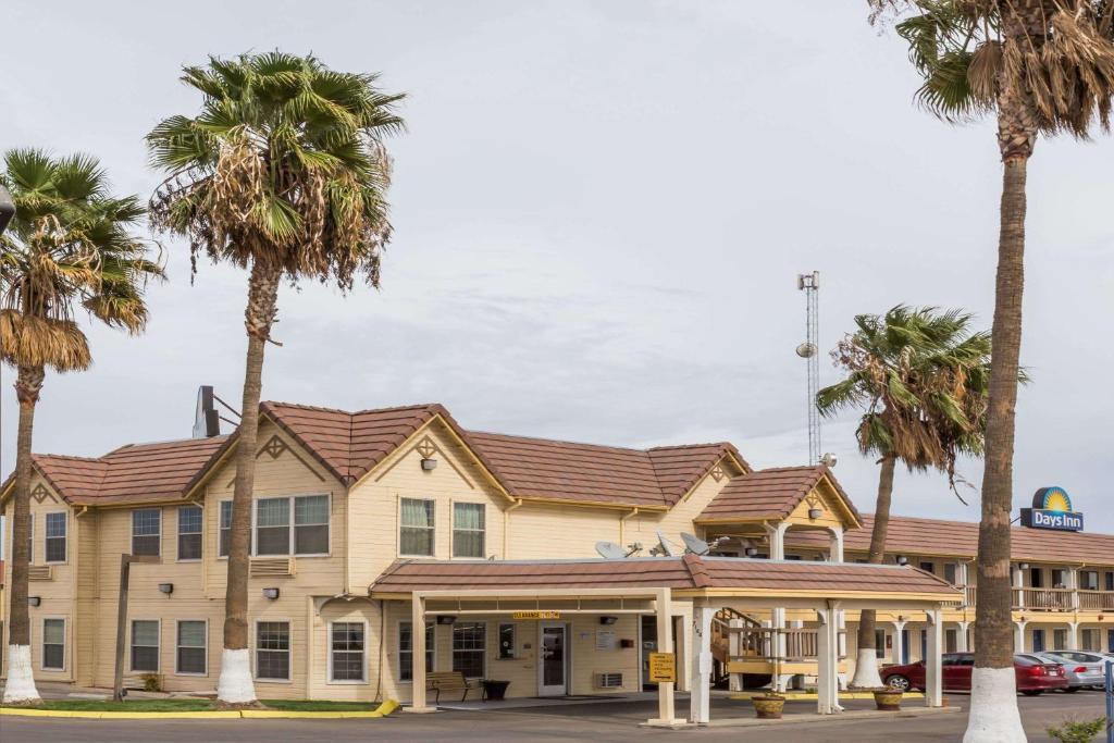 a hotel with palm trees in front of it at Days Inn by Wyndham Westley in Westley