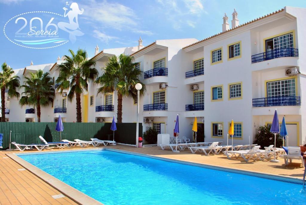 un hotel con piscina di fronte a un edificio di Apartamento com Piscina em Albufeira, Praia da Oura ad Albufeira