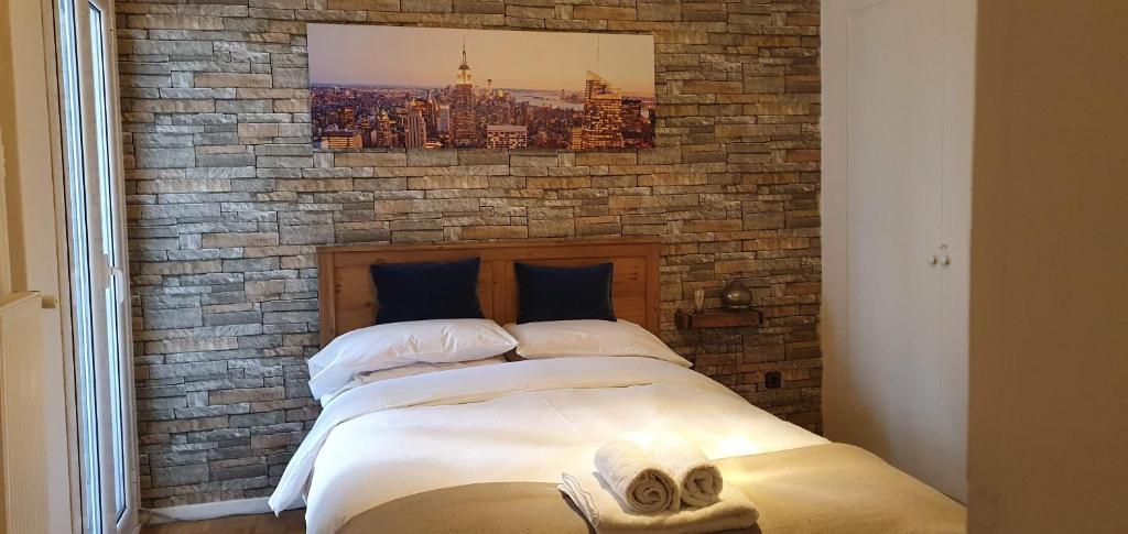 uma parede de tijolos com uma cama num quarto em Sofia Urban Acropolis Appartment em Atenas