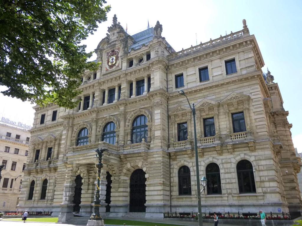 un gran edificio de piedra con una torre de reloj. en Habitación con baño privado en el centro de Bilbao, en Bilbao