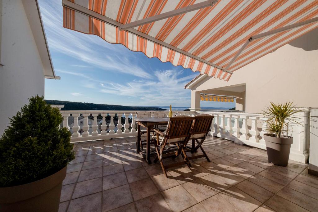 a patio with a table and chairs on a balcony at Apartment Starčević in Kampor