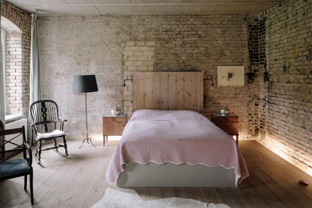 ein Schlafzimmer mit einem Bett und einer Ziegelwand in der Unterkunft Apartment im Kranich Hotel in Hessenburg