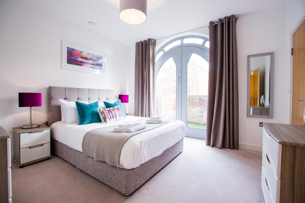 ein Schlafzimmer mit einem Bett und einem großen Fenster in der Unterkunft Urban Living's ~ King Edward Luxury Apartments in the heart of Windsor in Windsor