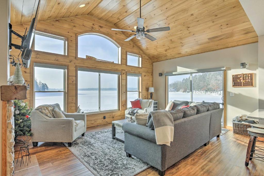 a living room with two couches and windows at Spacious Lakeside Family Home on Big Bearskin Lake in Hazelhurst