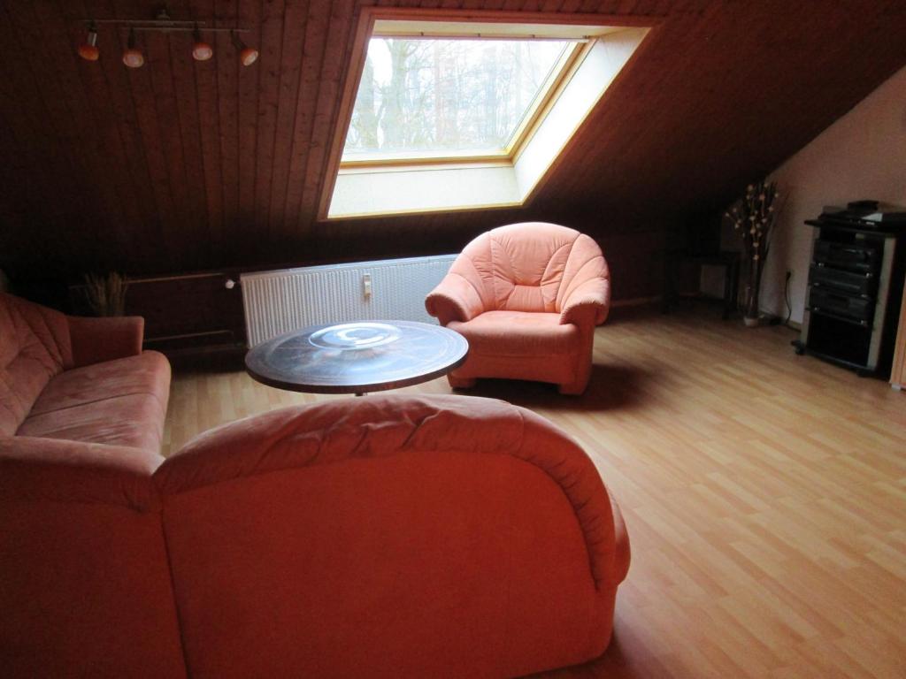 塞爾布的住宿－FeWo Ahornweg，客厅配有两把椅子、一张桌子和一扇窗户